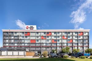 a large building with red and gray windows at Best Western Plus Toronto Airport Hotel in Mississauga