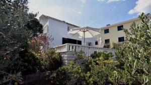a white house with an umbrella on a fence at Apartment Ela in Rogač