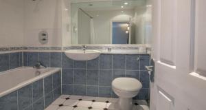 a bathroom with a sink and a toilet and a bath tub at Best Western Moore Place Hotel in Milton Keynes