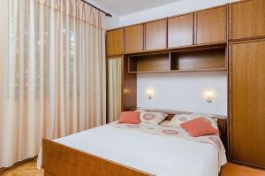 ein Schlafzimmer mit einem großen Bett mit Holzschränken in der Unterkunft House Marko in Orebić