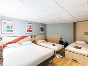 a room with two beds in a room with at ibis budget Angoulême Centre in Angoulême