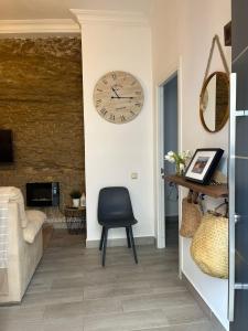 a room with a chair and a clock on the wall at Casa isabel in Setenil