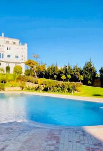 a large swimming pool in front of a building at appartement de vacances achakar plage & piscine & wifi in Tangier