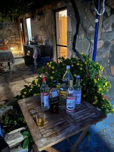 a wooden table with bottles and glasses on it at Mountain Stone Rooms in Mariaí