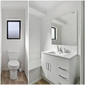 a white bathroom with a toilet and a mirror at MiddleIsland-FREE & FAST wifi NETFLIX & aircon in Taupo