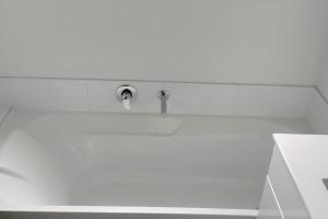 a bathroom sink with a faucet on a wall at MiddleIsland-FREE & FAST wifi NETFLIX & aircon in Taupo +13 photos