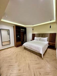 een slaapkamer met een groot wit bed en een spiegel bij Centrico 9 Tanger Bendiban in Tanger