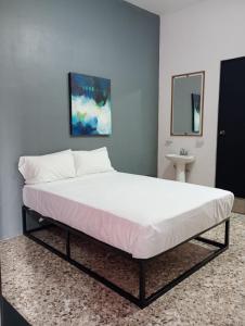 a large bed in a room with a mirror and a sink at Unidades Privadas con AC-TV-WiFi y Estacionamiento en Centro de MTY in Monterrey