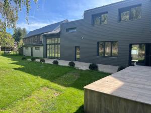 a large house with a large yard in front of it at Maison bord de rivière calme jaccuzi in Trooz