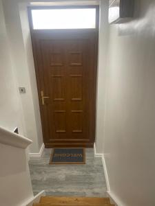 a hallway with a door with a sign in front at Cozy Studio Flat Romford, London in Romford