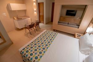 a room with a bed and a table and chairs at Hot Springs Flat Apart-Hotel Master Luxo com Banheira in Caldas Novas