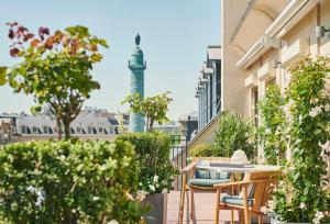 a balcony with tables and chairs with a view of a mosque at Park Hyatt Paris - Vendôme in Paris