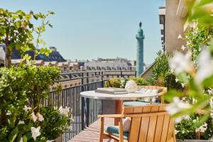 a table on a balcony with a view of the eiffel tower at Park Hyatt Paris - Vendôme in Paris