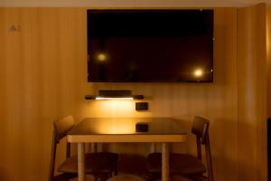 库纳巴拉布兰Mu S Boutique Motel "Matthew Flinders"的一张桌子、椅子和墙上的电视