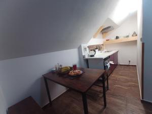 una piccola cucina con tavolo e ciotola di frutta di Zimmerův Statek a Mikulášovice