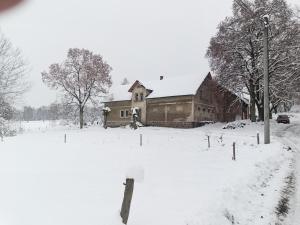 una casa in un campo ricoperto di neve di Zimmerův Statek a Mikulášovice