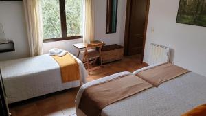 a bedroom with two beds and a table and a window at Casa con piscina en Parque Nacional de Cabañeros in Navas de Estena