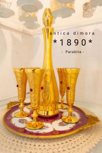 a group of gold vases and glasses on a table at Dimora 1890 in Parabita