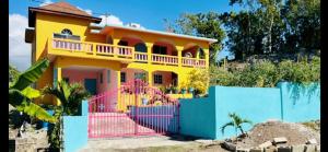 a house with a colorful fence in front of it at Coral Cove Cottage in Negril