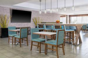 a dining room with a table and chairs and a tv at Hampton Inn Martinsburg in Martinsburg