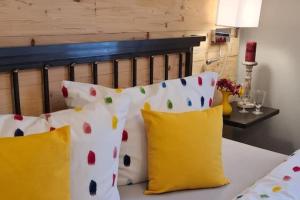 a bed with yellow and white pillows on it at Ferienwohnung Rose in Peißenberg