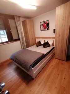a bedroom with a bed in a room with wooden floors at Ferienwohnung Apartment Alojamiento Casa Demy Frankfurt - Babenhausen Hessen Erdgeschoss in Babenhausen