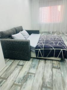 a bedroom with a bed and a couch at Квартира в новострое in Odesa