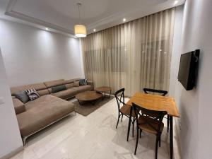 a living room with a couch and a table and chairs at Charmant appartement à Tunis ! in Tunis