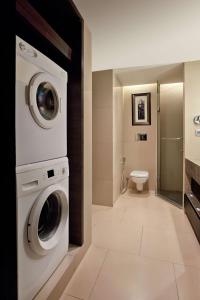 班加罗尔DoubleTree Suites by Hilton Bengaluru Outer Ring Road的配有洗衣机和卫生间的浴室