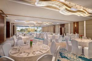a banquet hall with white tables and white chairs at Hilton Dubai Jumeirah in Dubai +186 photos