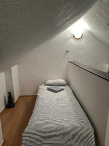 a small bedroom with a bed with a book on it at Jezero in Vrnjačka Banja