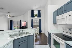 a kitchen with blue cabinets and a sink at Resort Community 4 Bedroom Family Home, Pool & 15 Min Disney in Kissimmee