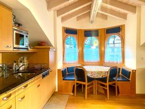 a kitchen with a table and chairs in a room at Heidahüs Penthouse in Grächen