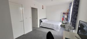 ein kleines Schlafzimmer mit einem Bett und einem Bücherregal in der Unterkunft Stretford Townhouse Bedroom in Manchester