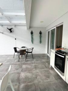 Una cocina y un comedor con mesa y sillas. en Cobertura Santorini Nova com Spa e Solário na Praia Grande, en Ubatuba
