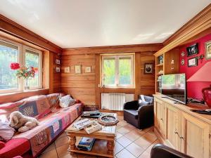 a living room with a couch and a tv at Chalet Les Elfes - Chalet Les Elfes — Luxe et confort pour un séjour MAE-7361 in Les Allues