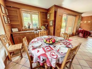 a dining room with a table with a bowl of fruit on it at Chalet Les Elfes - Chalet Les Elfes — Luxe et confort pour un séjour MAE-7361 in Les Allues