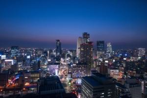 una città illuminata di notte con di Hilton Nagoya Hotel a Nagoya