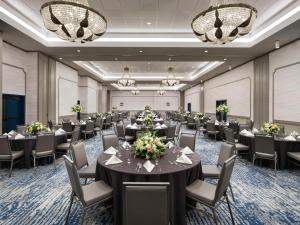 默特尔比奇Embassy Suites by Hilton Myrtle Beach Oceanfront Resort的一间会议室,配有桌椅和吊灯 更多37张照片