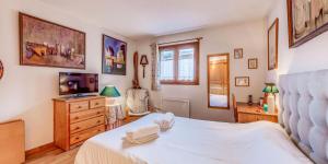 a bedroom with a bed and a television in it at Chalet Le Prairial - Chalets pour 8 Personnes MAE-0071 in Champagny-en-Vanoise