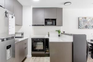 a kitchen with stainless steel appliances and gray cabinets at More Echevarriarza apartamento de estreno!! in Montevideo