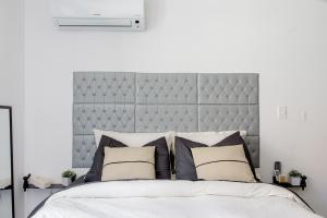 a white bedroom with a large bed with pillows at More Echevarriarza apartamento de estreno!! in Montevideo