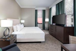 圣路易斯Hilton Pennywell St Louis at the Arch的一间配有床和平板电视的酒店房间