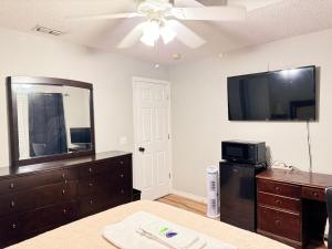 een slaapkamer met een dressoir en een flatscreen-tv bij Near Disney cozy quiet place can stay up to 4 people in Orlando