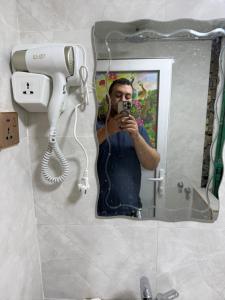 a man taking a picture of himself in a bathroom mirror at Sarko hotel فندق سركو in Baghdad