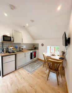 a kitchen with a wooden table and a kitchen with a desk at Loft cottage in Bonsall
