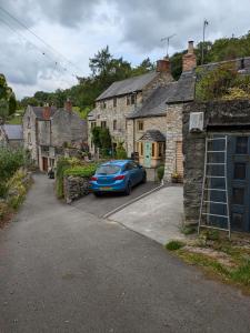 a blue car parked in a parking lot in a village at Loft cottage in Bonsall