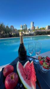a plate of fruit with a bottle of wine and glasses at More Echevarriarza apartamento de estreno!! in Montevideo