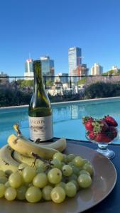 a bottle of wine and a plate of bananas and grapes at More Echevarriarza apartamento de estreno!! in Montevideo