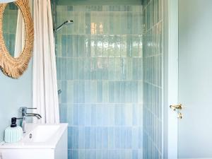 a bathroom with a shower with a sink and a mirror at 6 person holiday home in Faaborg-By Traum in Fåborg +35 photos
